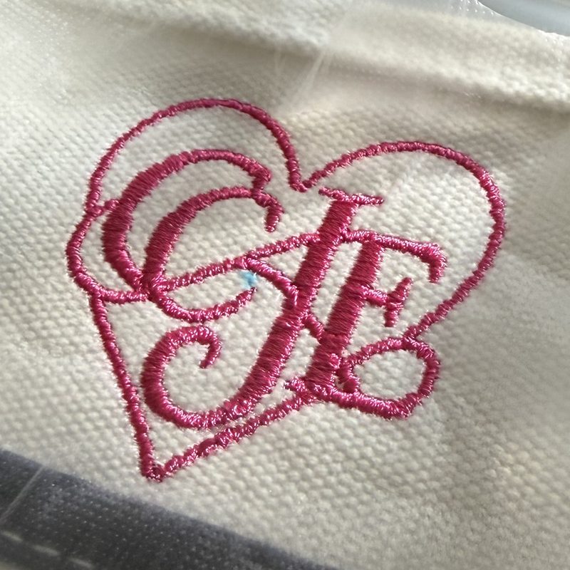 The same CJF heart monogram stitched in pink satin on a white canvas tote